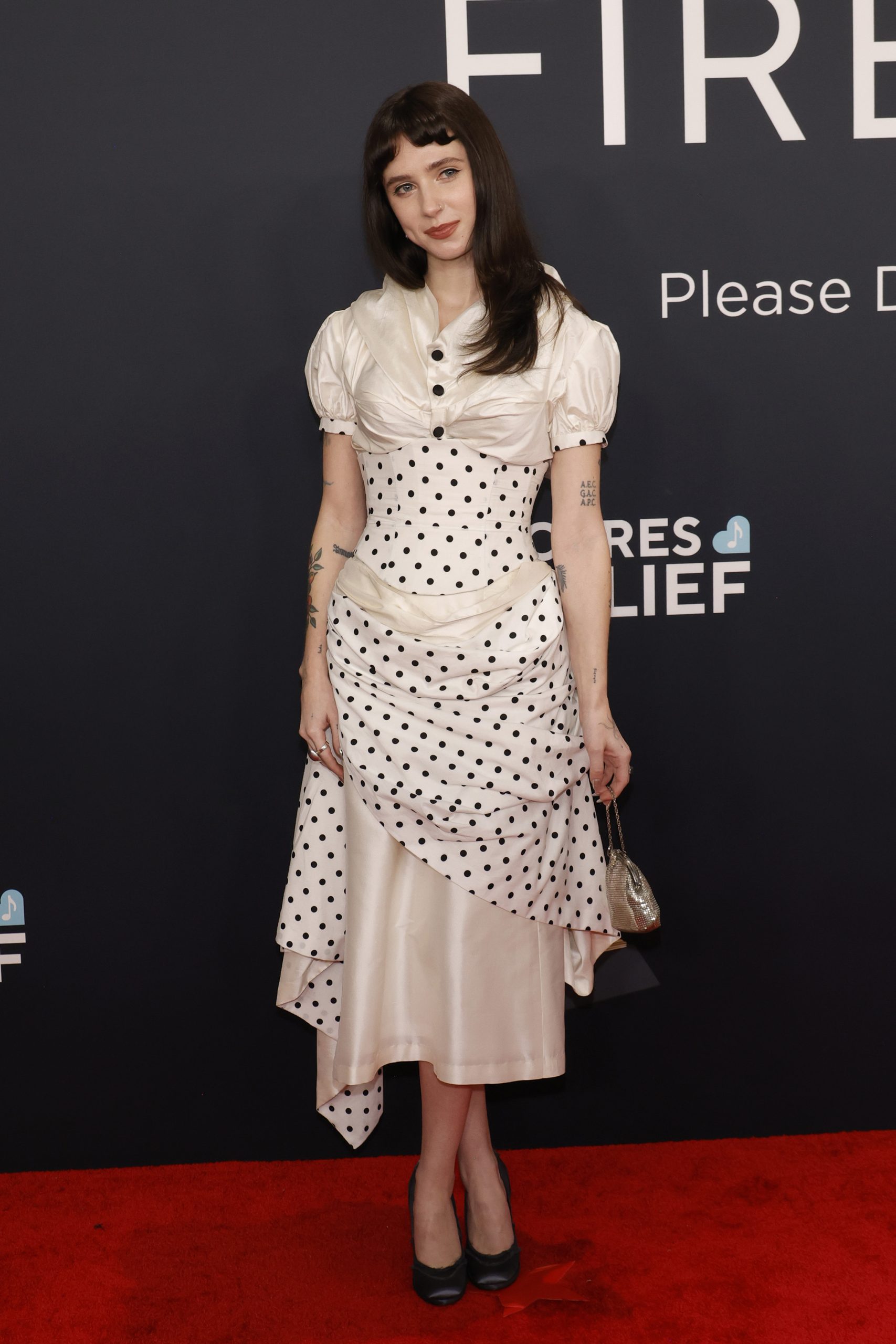 clairo wears a dress covered in polka dots at the grammys