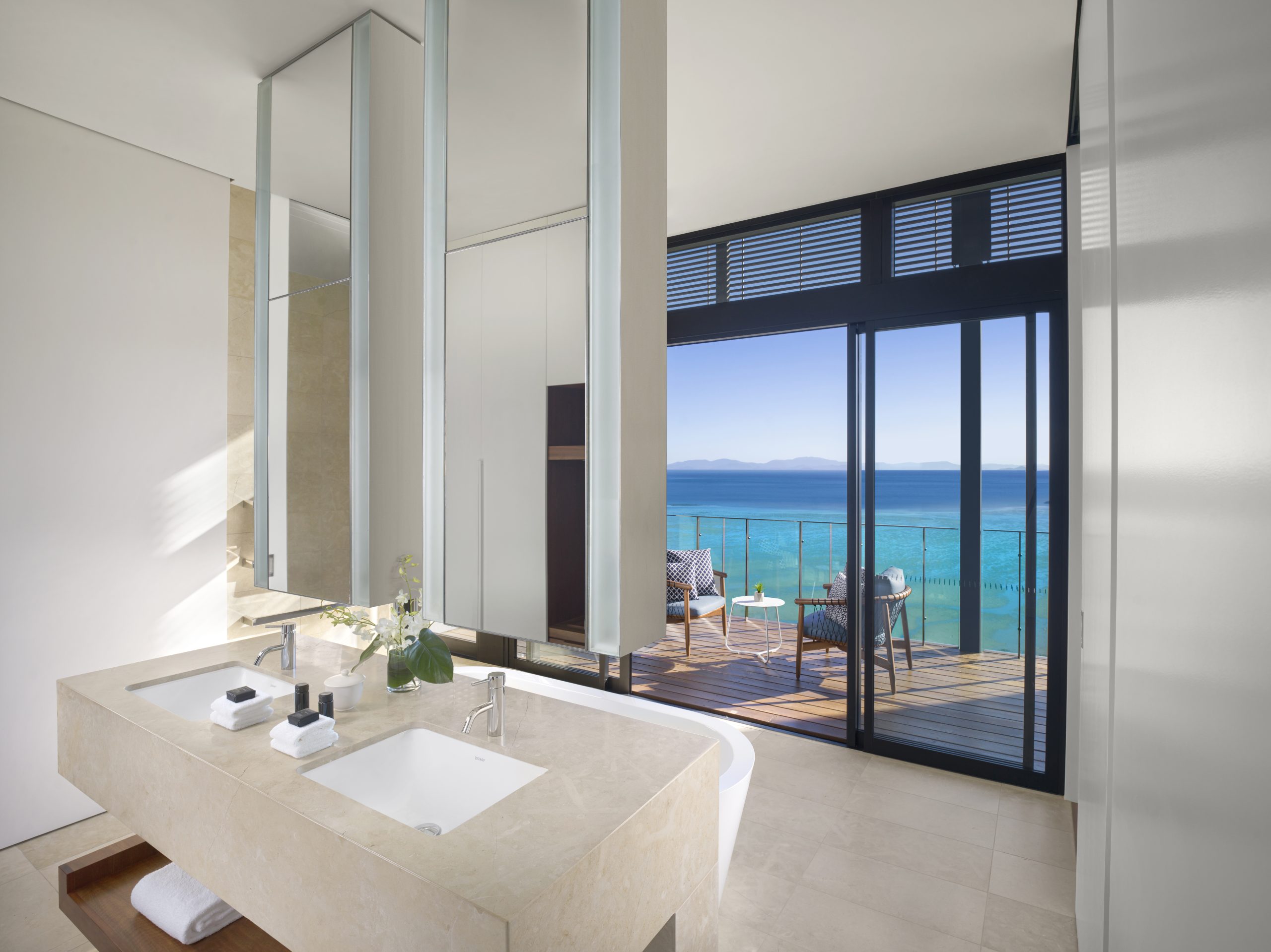 a bathroom with a large window overlooking the ocean